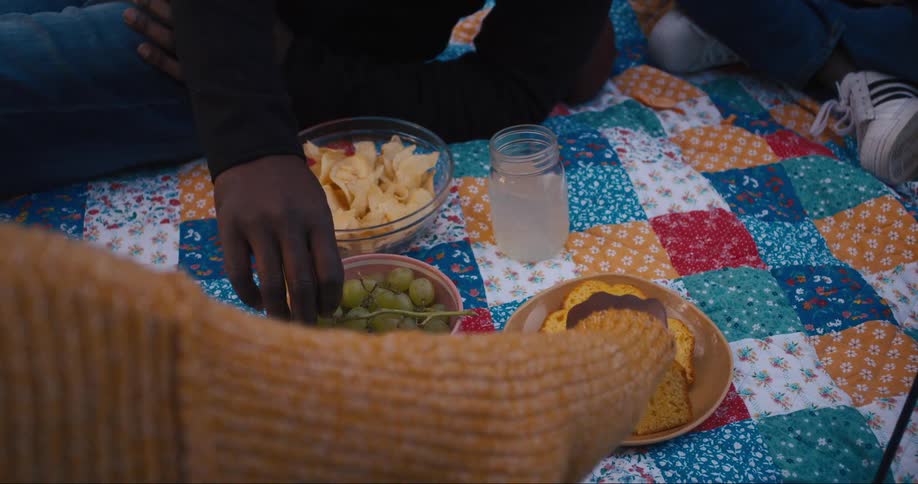 Friends are having a picnic and are eating food together