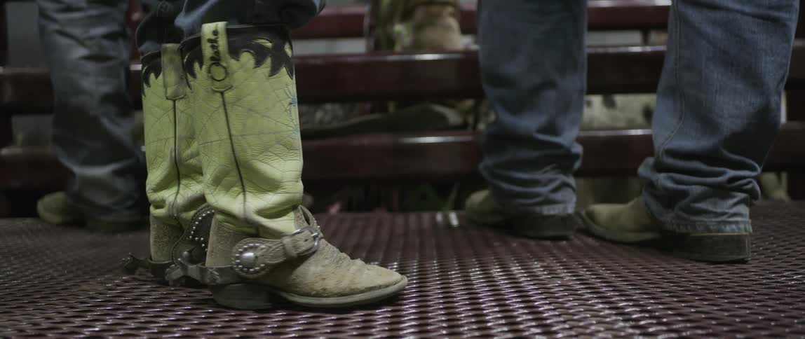 A man with boots walks away from others