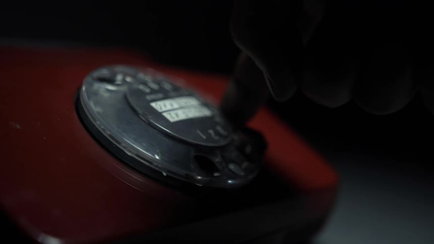 A finger dialing a rotary phone
