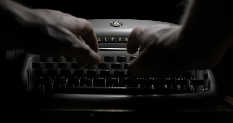 A man typing on a manual typewriter