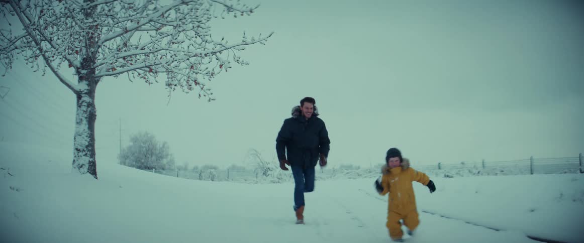 A father and son are running in the snow playing