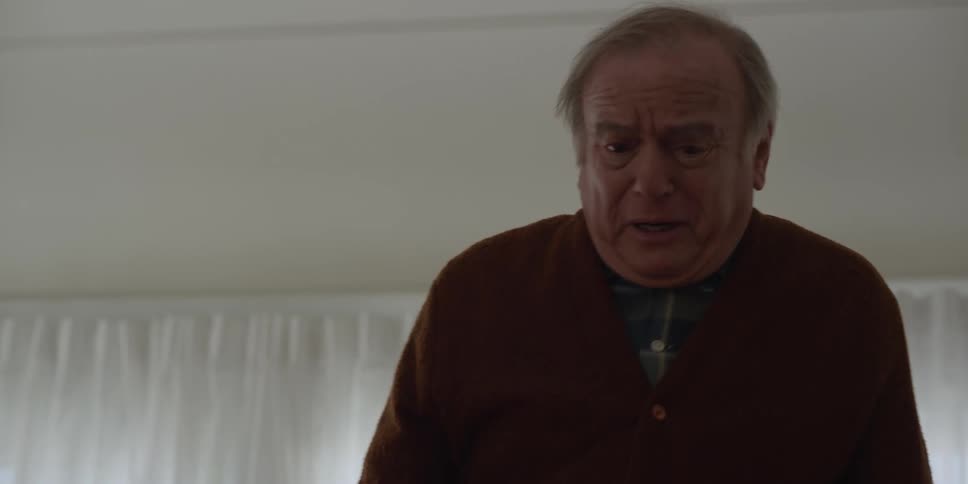 Sad agitated elderly man talks to person and bursts into tears in room