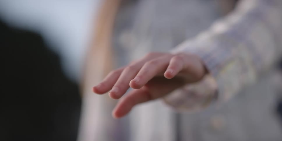 A girl raises her arm and holds it in front of her