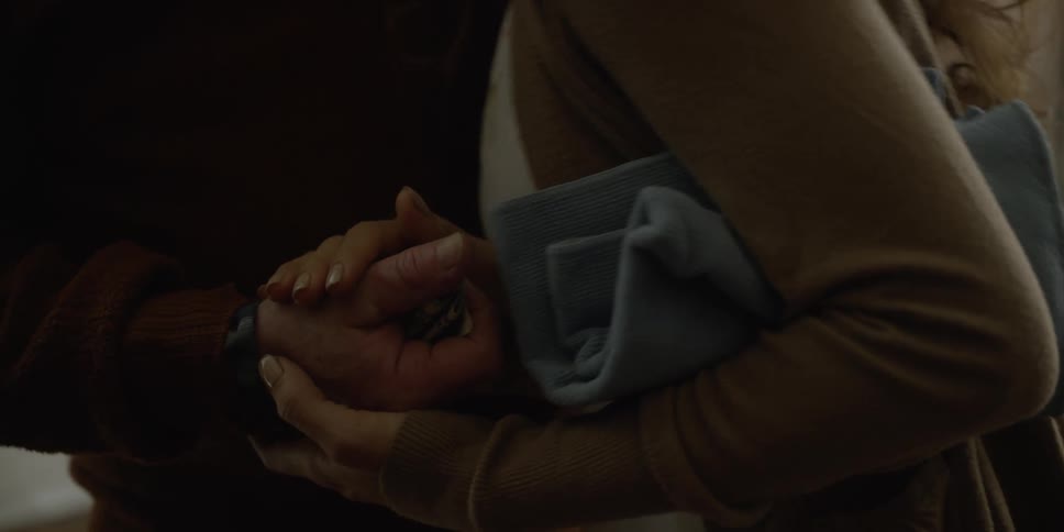 An elderly man holds some money out to his teenage grand daughter who closes his hand over the money and kisses him and walks away