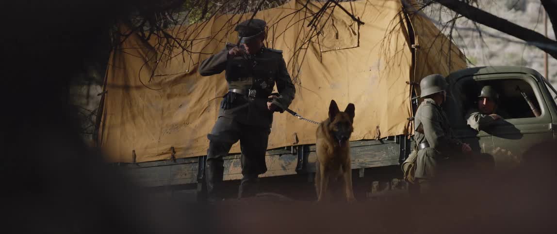 Army people are outside with a dog in the middle of the day time