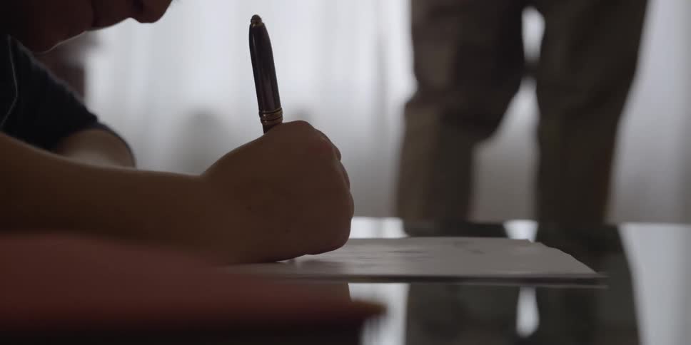 A child using a pen to write on a piece of paper