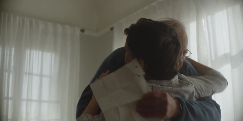 Boy cuddles grandfather wearing glasses and blue sweater and having a sudden sharp feeling