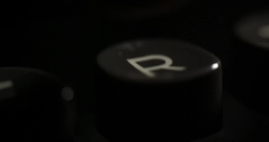 A finger presses a typewriter button