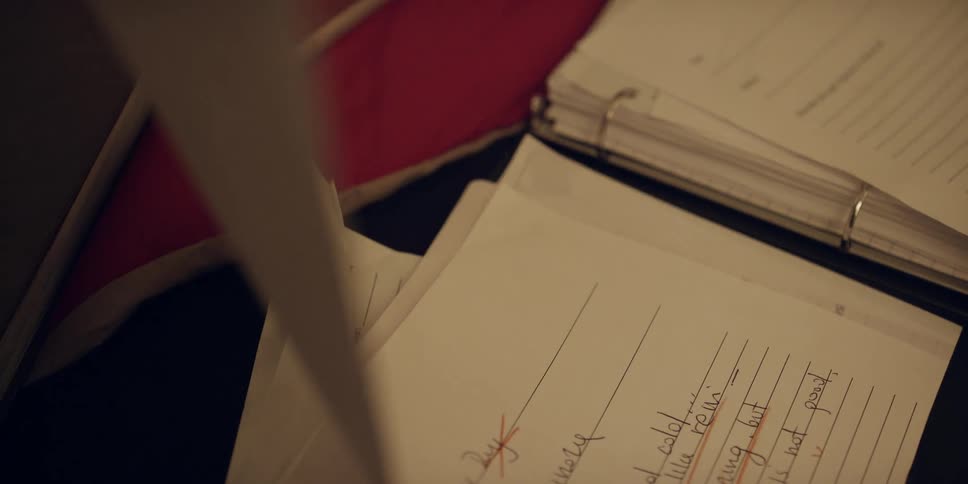 A woman takes lifts up her childs school work with a failing grade on it