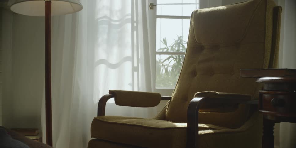 An armchair near a window in a house during the day