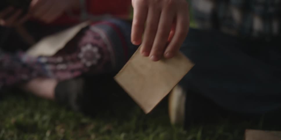 A child lifts a piece of paper from the box