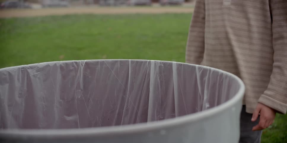 A child reaches into the garbage can