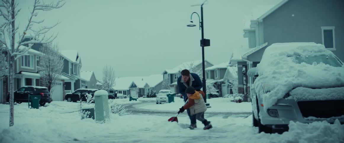Boy pushes shovel with his father