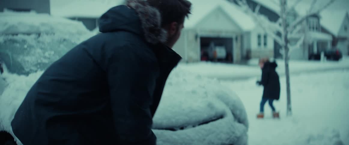 A father and young daughter having a snowball fight in their front yard on a winter day