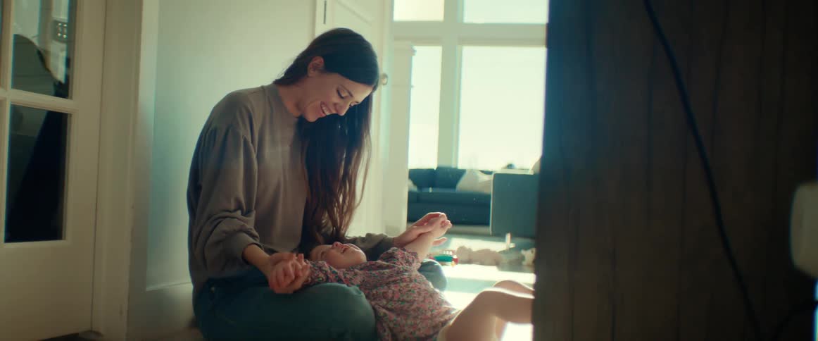 A woman is playing with her child and smiling
