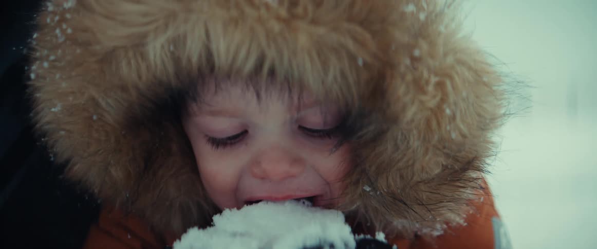 Close up face of a boy eating snow
