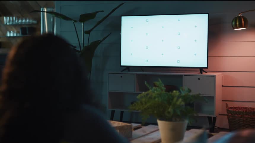 A woman is sitting on a couch and texing on her phone