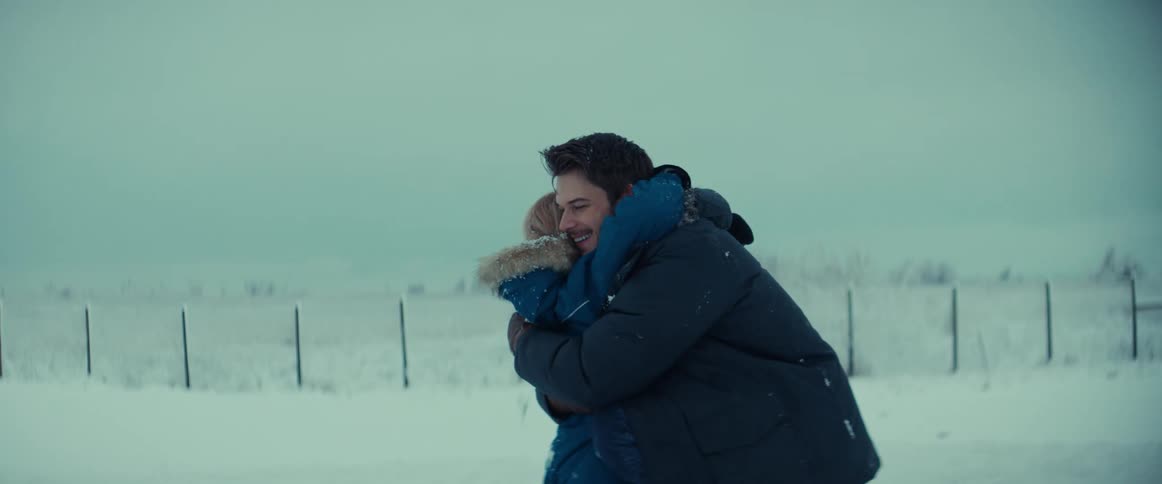 A father hugging his young daughter outside on a cold winter day