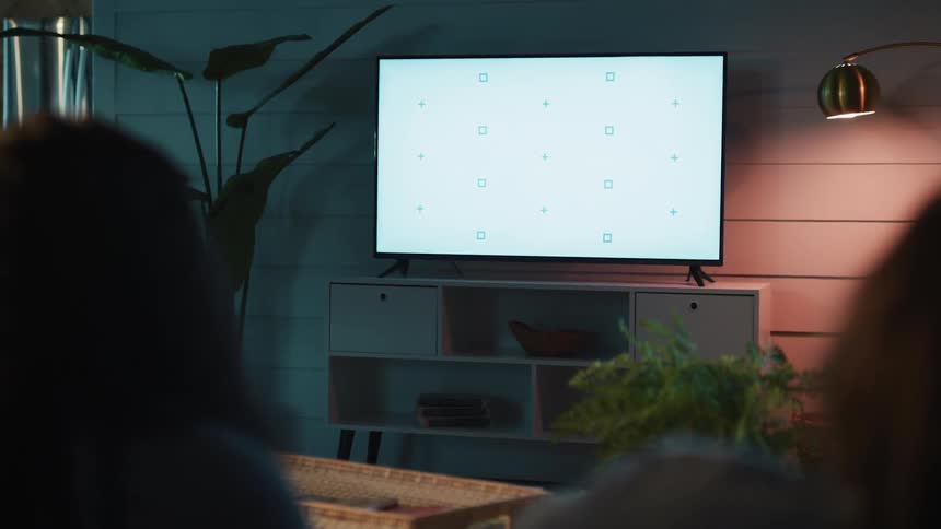 Two people watching television from a living room sofa