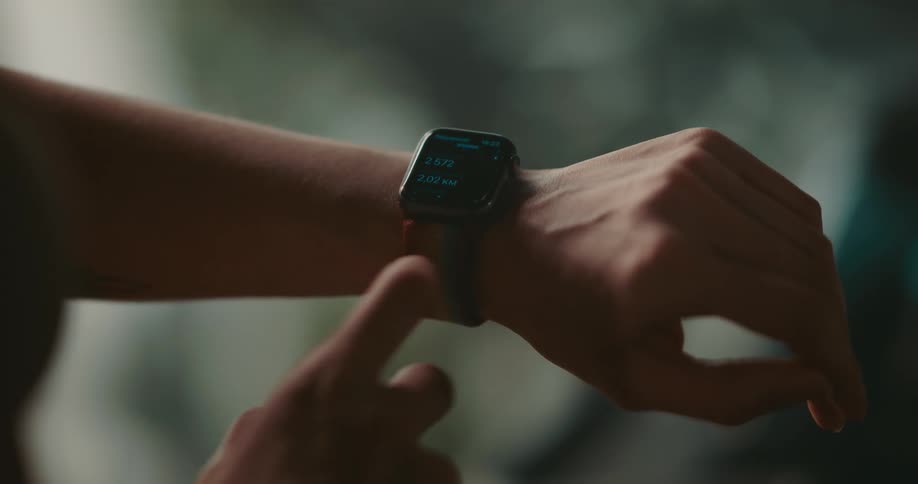 A woman checks a fitness app on her smartwatch
