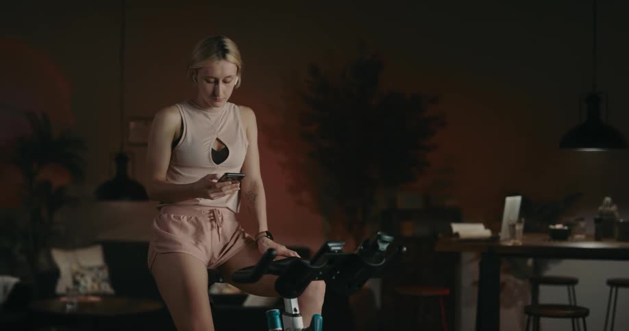 A young woman is working out and on her phone
