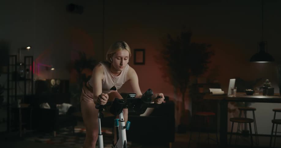 A woman puts in earbuds before working out at home
