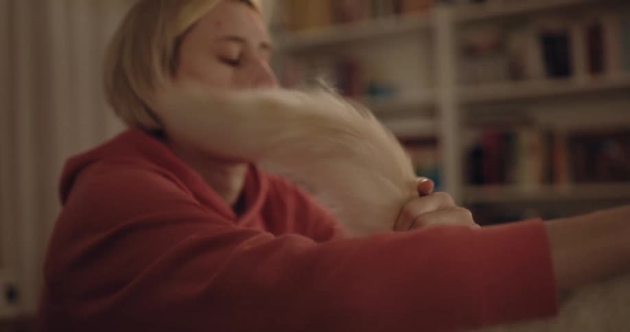 A woman petting a cat in a room