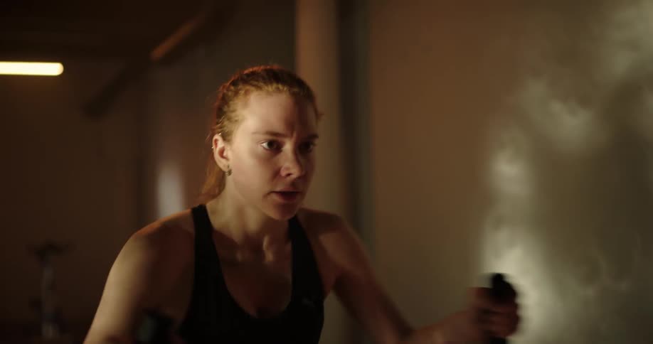 A womans arms are moving vigorously as she works out on an exercise machine