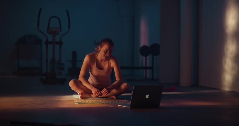 A woman exercising in front of a computer
