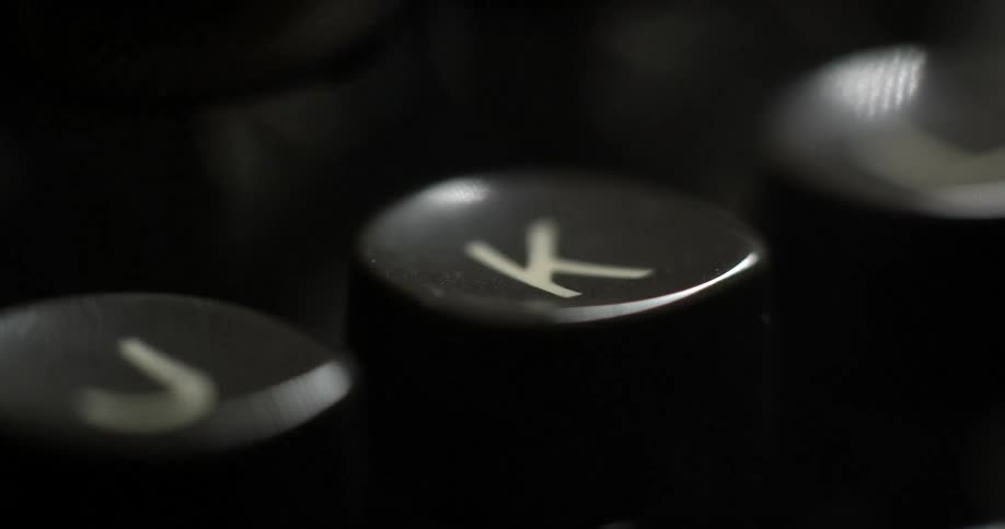 Extreme close-up of someone  pressing a key on a very old typewriter