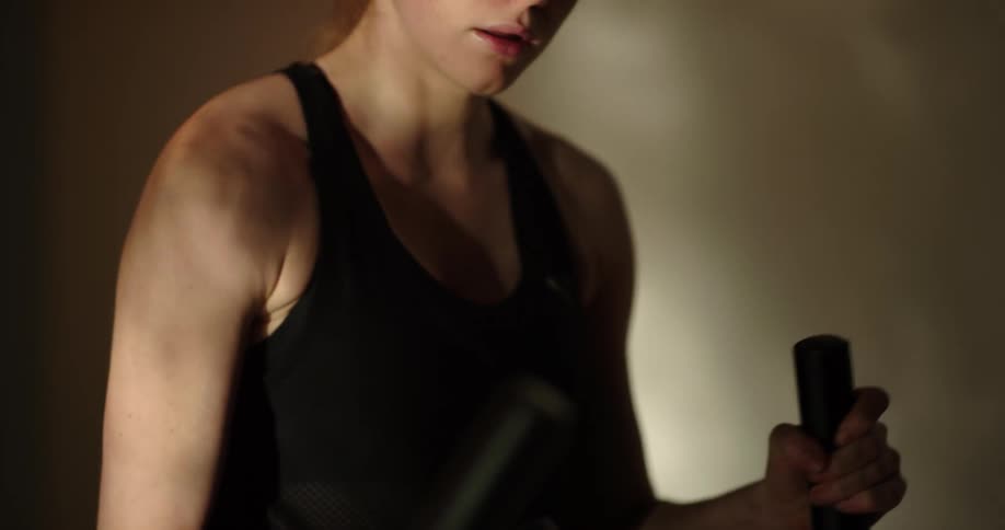 A young woman is drinking water and working out