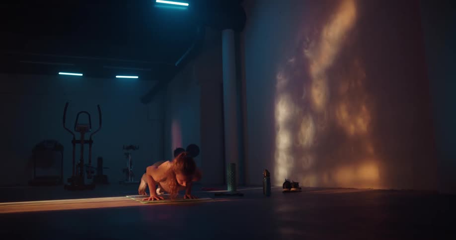 Woman practices yoga in room near wall dappled with shadows