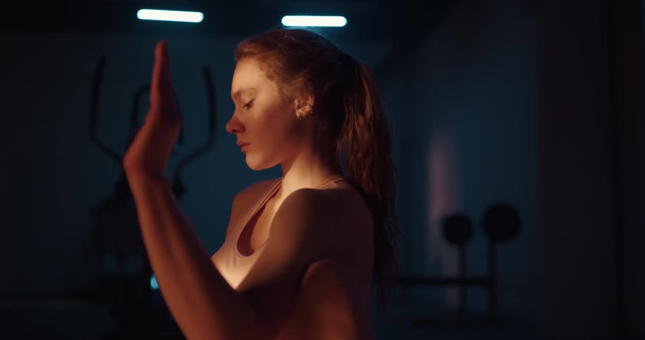 A woman stretching and holding a pose in a fitness room