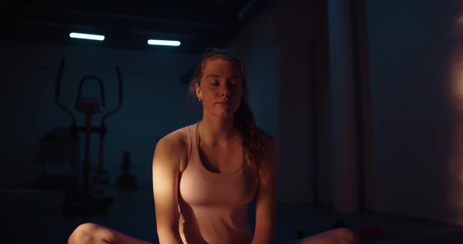 A woman smiling while stretching on a yoga mat