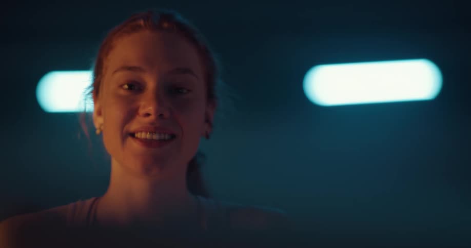 A young woman is smiling and talking to the camera