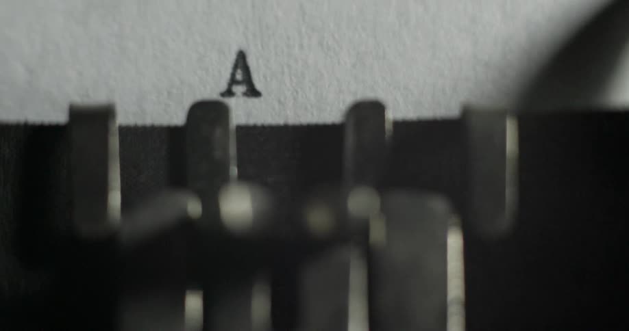A typewriter slowly types out letters on paper