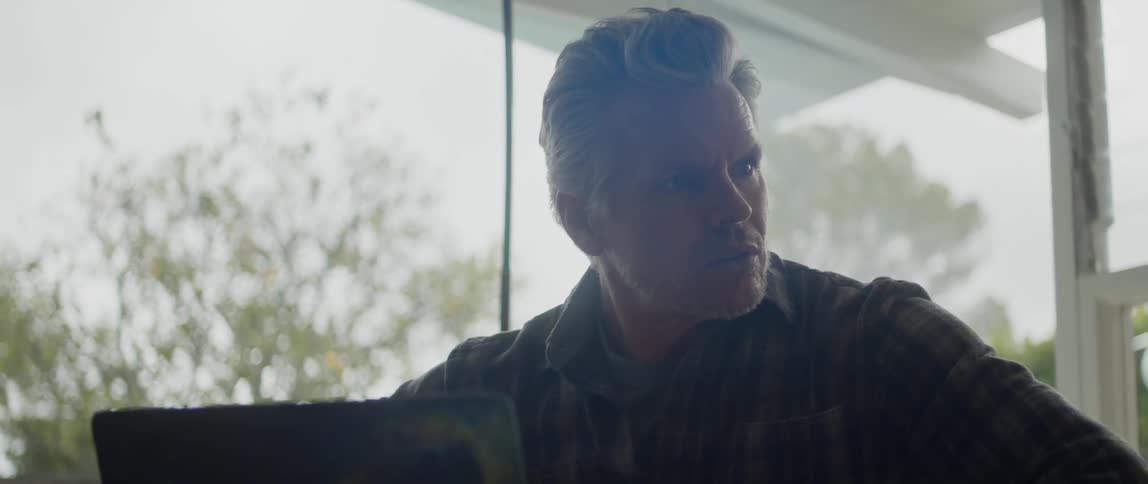 A man sits worried by his laptop
