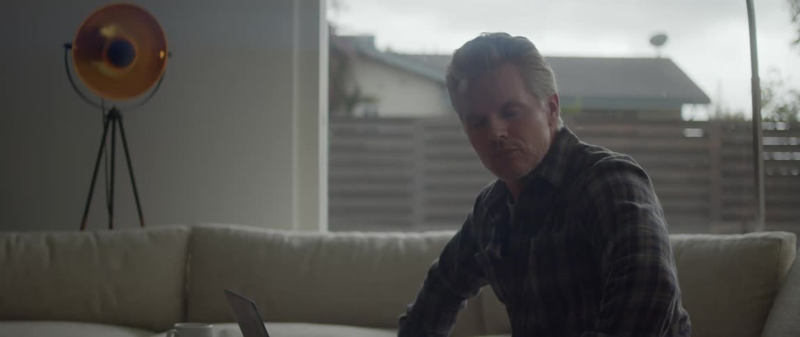Man sitting on a couch at home near the windows impatiently waiting