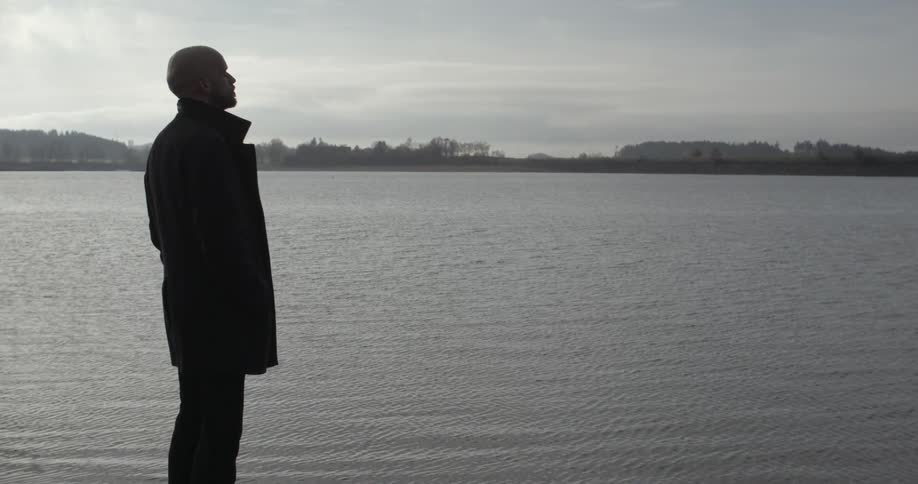 Man on shore looking out to sea