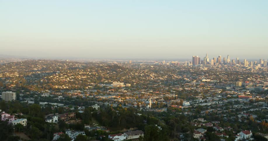 An aerial shot of a large city with skyscrapers off on the horizon and the suburbs surrounding it