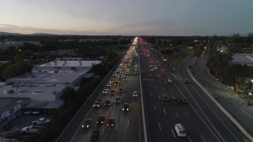 The view is of the downtown area and cars are driving down the highway