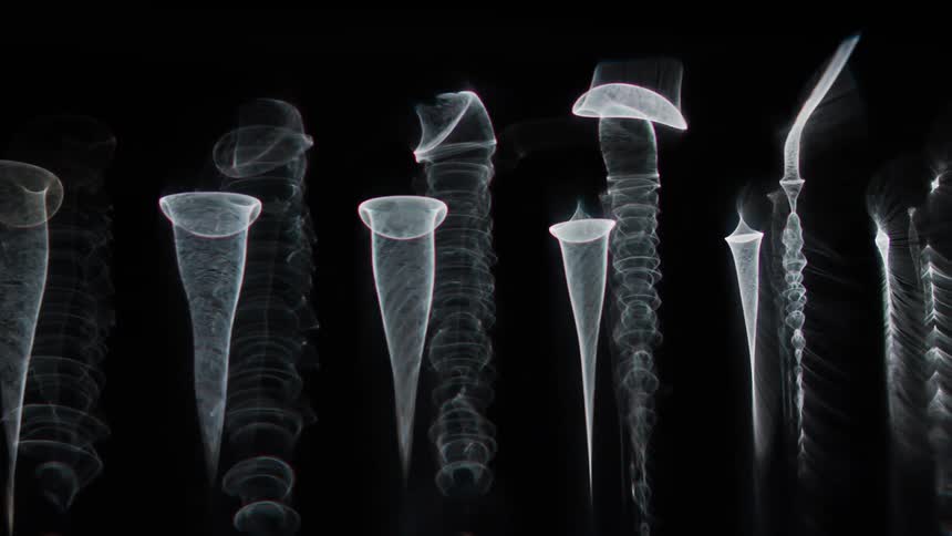 Glowing translucent cones move across the darkness as wisps of light spread as they turn