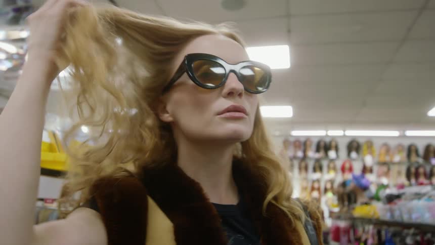 A woman tries on sunglasses in the store