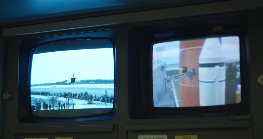 A space shuttle launch on display on two monitors
