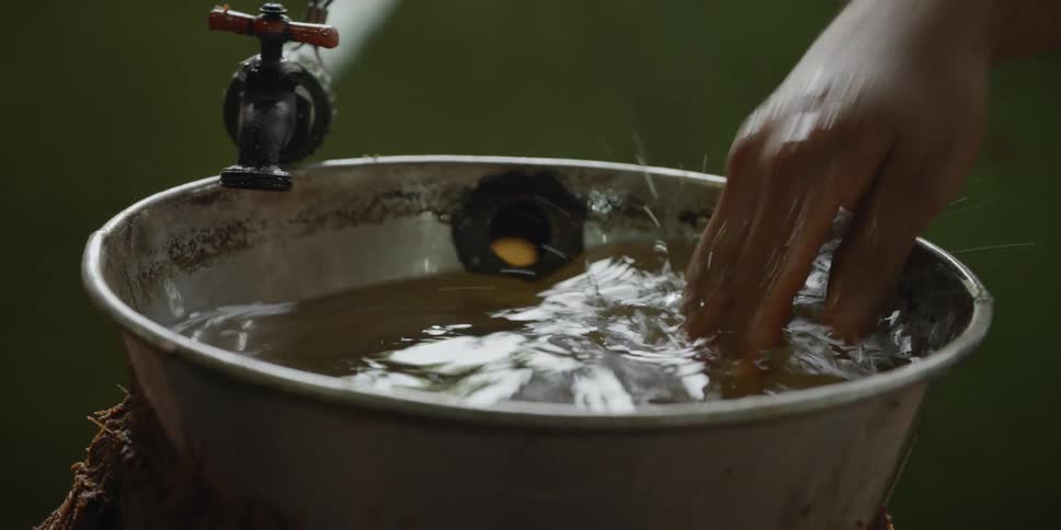 Water from a faucet fills a galvanized steel tub
