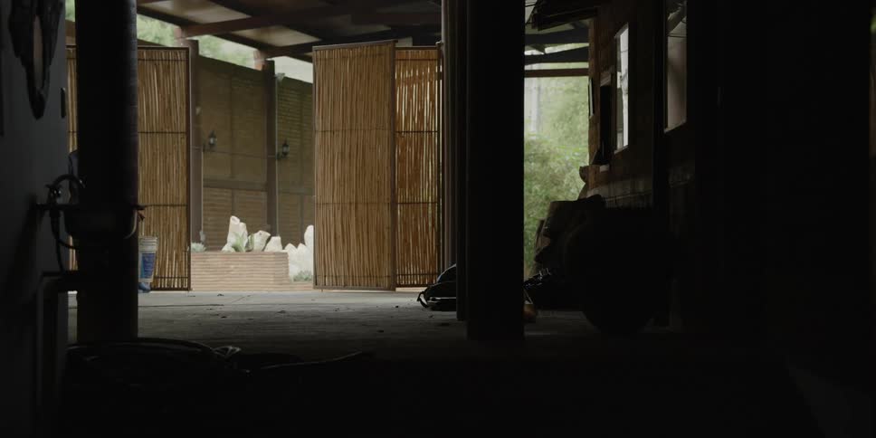 A farmer is walking into the barn in the middle of the day time