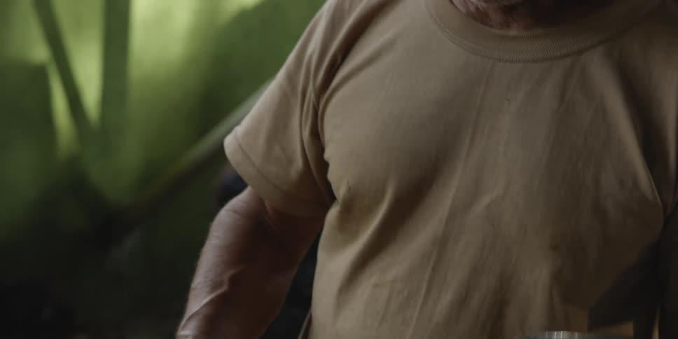 A man is working outdoors and pouring some water