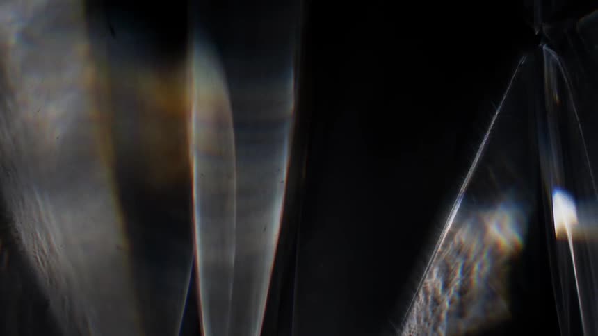 Light moves across the darkness as soft wisps emerge from the light