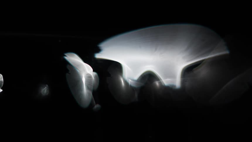 Lights move across the darkness with growing illuminated wisps spreading as they move