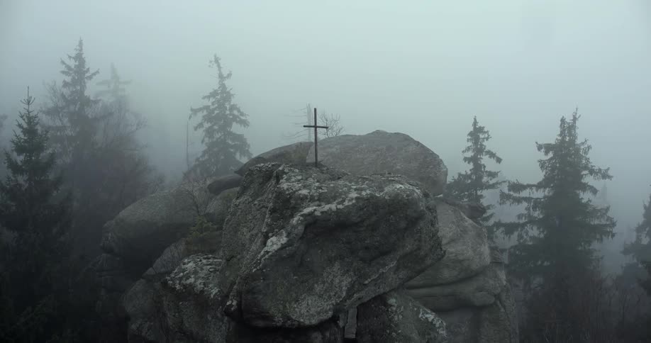 Cross standing atop a tall rock formation